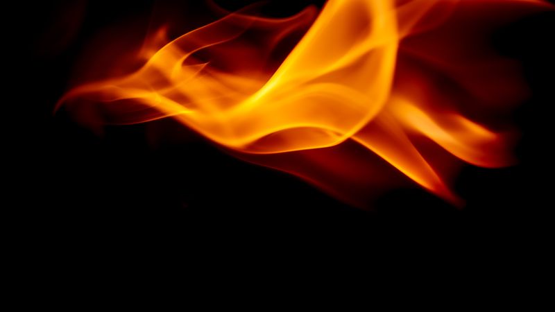 Close-up of bright orange flames against a dark background.